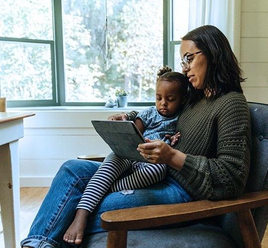 mom and daughter on laptop in rural home